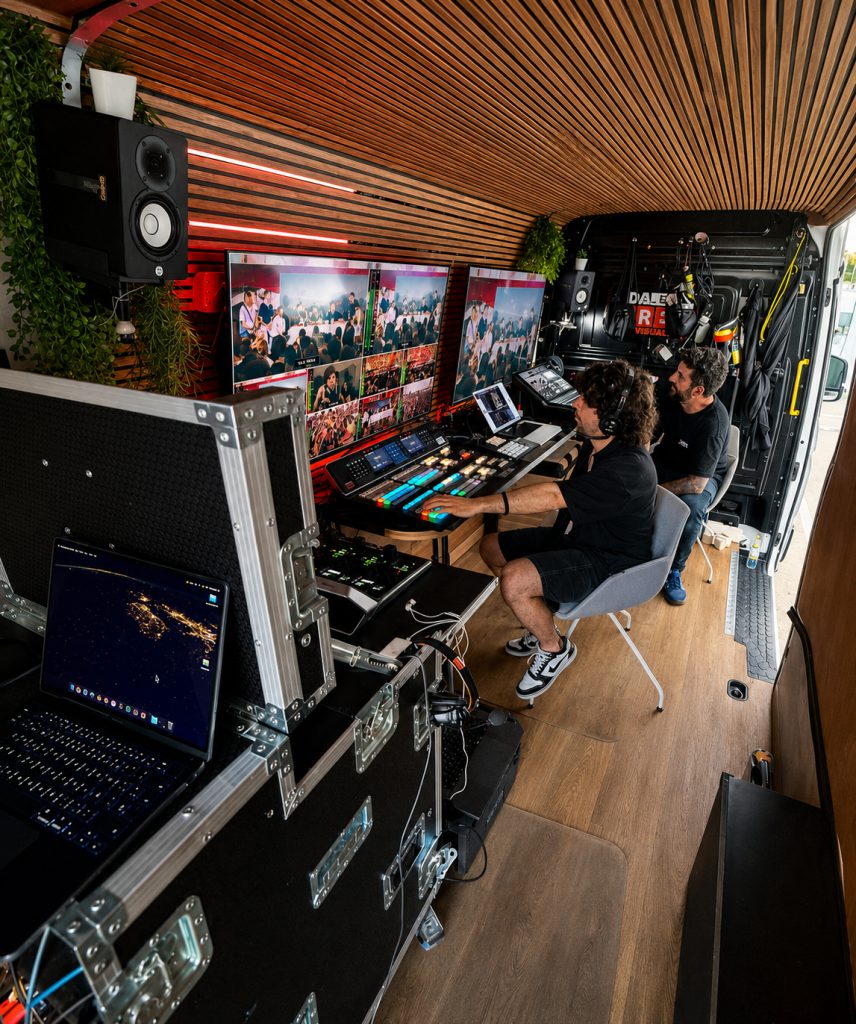 Interior de la unidad móvil: realizador y técnico trabajando sobre el mezclador ATEM con el multiview en pantalla