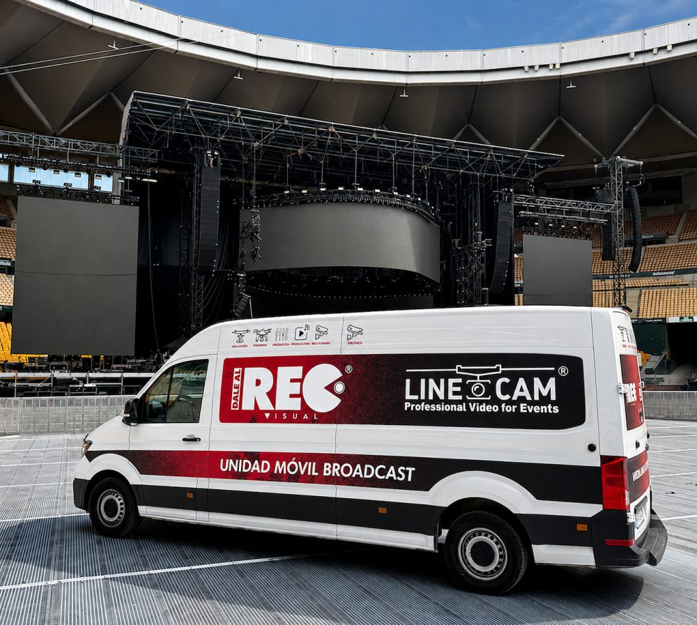 Unidad móvil broadcast de Linecam y Dale al REC aparcada frente al escenario de un estadio antes de un concierto